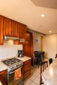 a kitchen with wooden cabinets and a stove top oven at El Suburbio - Morelos Sur in Morelia