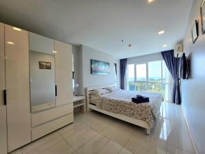 a bedroom with a bed and a large window at One Tower 84 by ThaiminatorPattaya in Pattaya South +12 photos