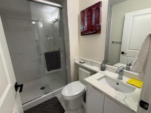 a bathroom with a shower and a toilet and a sink at Private Bachelor Suite Near PNE in Vancouver +15 photos