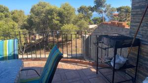 a grill on a balcony with a fence and trees at villa larhat vue sur mer in Larhat