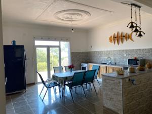 a kitchen with a table and chairs in a room at villa larhat vue sur mer in Larhat