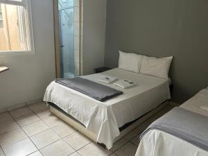 a bedroom with a bed and a glass shower at Hotel Castro Alves, São Paulo in São Paulo