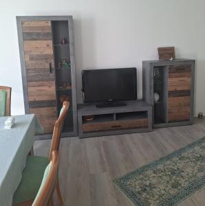 a living room with a tv and a entertainment center at Ferienwohnung Egbert in Weißwasser