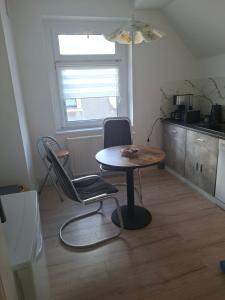 a room with a table and a chair and a kitchen at Ferienwohnung Egbert in Weißwasser