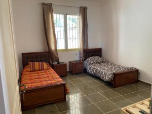 a room with two beds and a window at villa larhat vue sur mer in Larhat