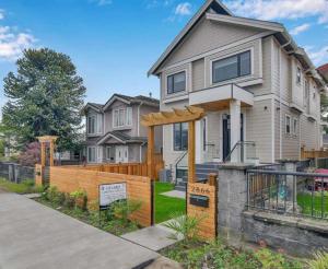 a house with a wooden fence in front of it at Private Bachelor Suite Near PNE in Vancouver