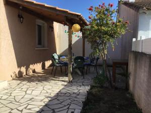 a patio with a table and chairs in a house at Marseillan in Marseillan