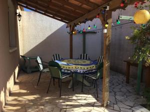 a patio with a table and chairs under a pergola at Marseillan in Marseillan