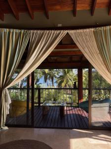 a room with a screened in porch with curtains at La Laguna in Saboga