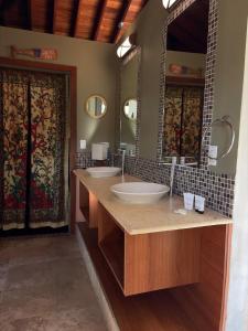 a bathroom with two sinks and a large mirror at La Laguna in Saboga