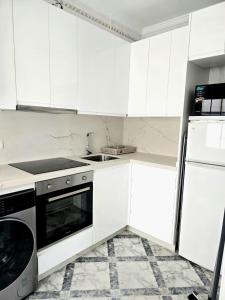 a kitchen with white cabinets and a stove top oven at PISO CENTRICO EN PUNTA UMBRIA in Punta Umbría