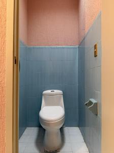 a bathroom with a toilet in a blue tiled wall at Hostal Punto Americana in Guadalajara +30 photos