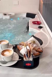 a tray with cups of coffee and pastries in a swimming pool at ANTO Wellness & Suite in Nova Siri Marina