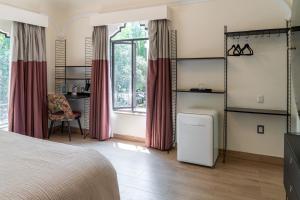 a bedroom with a bed and a desk and a window at Casa Amari in Mexico City