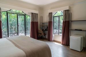 a bedroom with a bed and large windows at Casa Amari in Mexico City