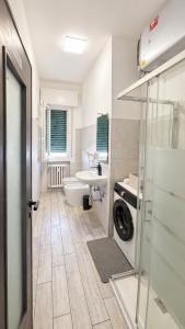 a bathroom with a sink and a washing machine at Modena Station - Suite H24 in Modena