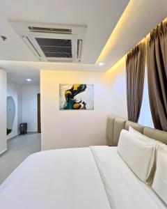 a bedroom with a white bed and a painting on the wall at The Mansion in Abuja