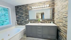 a bathroom with a sink and a tub and a mirror at Dalby Way in Austell