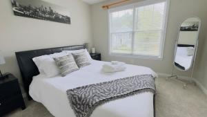 a bedroom with a large white bed with a mirror at Dalby Way in Austell +2 photos