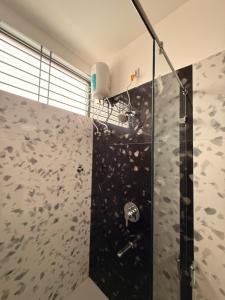 a bathroom with a shower with a glass door at The Lavish Landmark in Jorhat