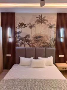 a bedroom with a large bed with a painting on the wall at The Lavish Landmark in Jorhat