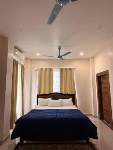 a bedroom with a bed with a ceiling fan at The Lavish Landmark in Jorhat +11 photos