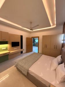 a large bedroom with a bed and a ceiling at The Lavish Landmark in Jorhat