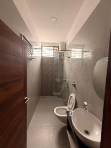 a bathroom with a toilet and a sink at The Lavish Landmark in Jorhat