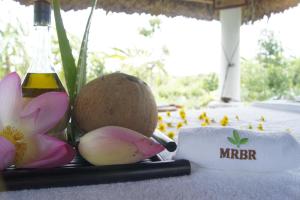 a table with a towel and a bottle of miter and a flower at Mekong Riverside Boutique Resort & Spa in Cái Bè