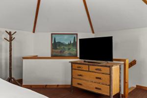 a bedroom with a television on a wooden dresser at Emerson Resort & Spa in Mount Tremper