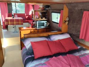 a bedroom with a bed with red pillows at Peniche Maryjeanne in Gannay-sur-Loire