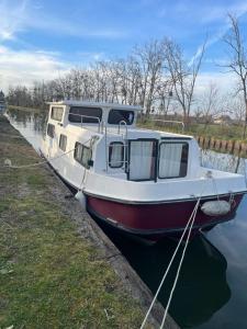 a boat docked in the water next to a wall at Peniche Maryjeanne in Gannay-sur-Loire