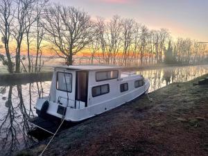 a small boat sitting on the shore of a lake at Peniche Maryjeanne in Gannay-sur-Loire