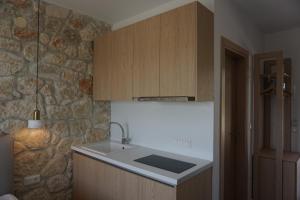 a kitchen with a sink and a stone wall at Aria Vista Chalkidiki in Agios Nikolaos