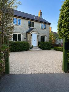 a house with a gravel driveway in front of it at The little Hotel-luxury home in Motcombe