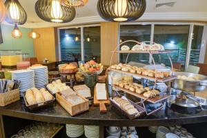 a buffet with bread and pastries on a table at Comfort Ibirapuera in São Paulo