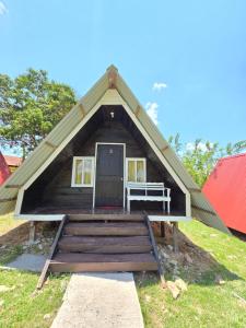 a small house with a pitched roof with a door at Cabañas Villa Aurora in Campamento