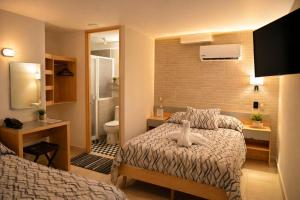 a small hotel room with a bed and a bathroom at El Suburbio - Morelos Sur in Morelia