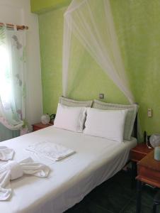 a bed with white sheets and white towels on it at Maria Charalampaki Studios in Skiros