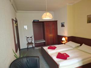 a hotel room with two beds and a chair at Weißes Roß Crossen in Ahlendorf