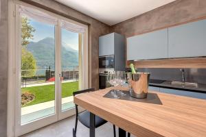 a kitchen with a wooden table and a large window at Villa Orchidea in Onno