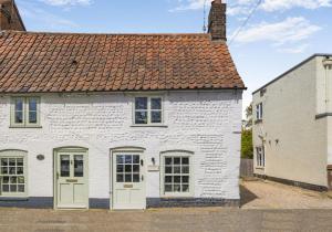 a white house with a red roof at 1 Bed in Holt oc-p34797 in Holt