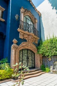 a blue building with a gate and a balcony at Casa Amari in Mexico City