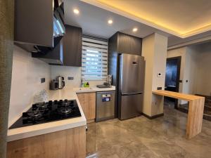 a kitchen with a stainless steel refrigerator and a counter at Albera Villas in Kemer