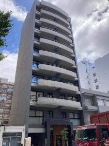 a tall building with a double decker bus in front of it at C&R Departamentos y Hoteles in Mar del Plata