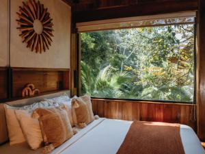 a bed in a room with a large window at Palmar Beach Lodge in Bocas Town