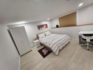 a bedroom with a bed and a desk in it at Garden City-Private 1BR Full Apt in Halifax