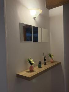 a bathroom with a shelf with flowers and a mirror at Affittacamere Castelmanardo in Amandola +21 photos