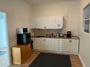 a kitchen with white cabinets and a microwave at Trevlig lägenhet centralt i Kumla in Kumla
