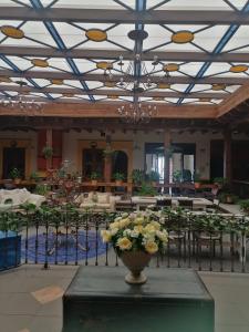 a room with a vase of flowers on a table at Casa de los Arcángeles in San Cristóbal de Las Casas